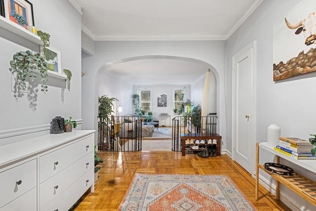 hall with arched walkways, baseboards, and ornamental molding