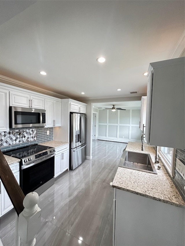 22 Peacock Ln, Levittown, NY 11756 - kitchen featuring backsplash, a sink, light stone counters, ceiling fan, and appliances with stainless steel finishes