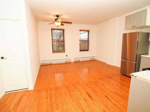 unfurnished living room featuring a ceiling fan, light wood-style floors, a baseboard radiator, and baseboards