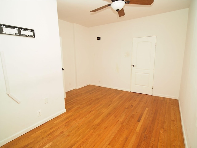 unfurnished room featuring ceiling fan, light wood-style flooring, and baseboards
