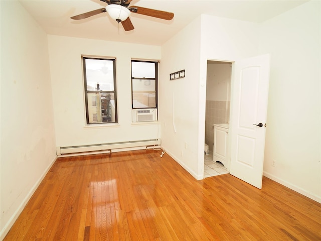 unfurnished room featuring baseboard heating, light wood-type flooring, a ceiling fan, and baseboards