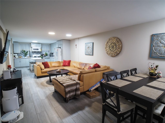 living area featuring light wood finished floors and recessed lighting