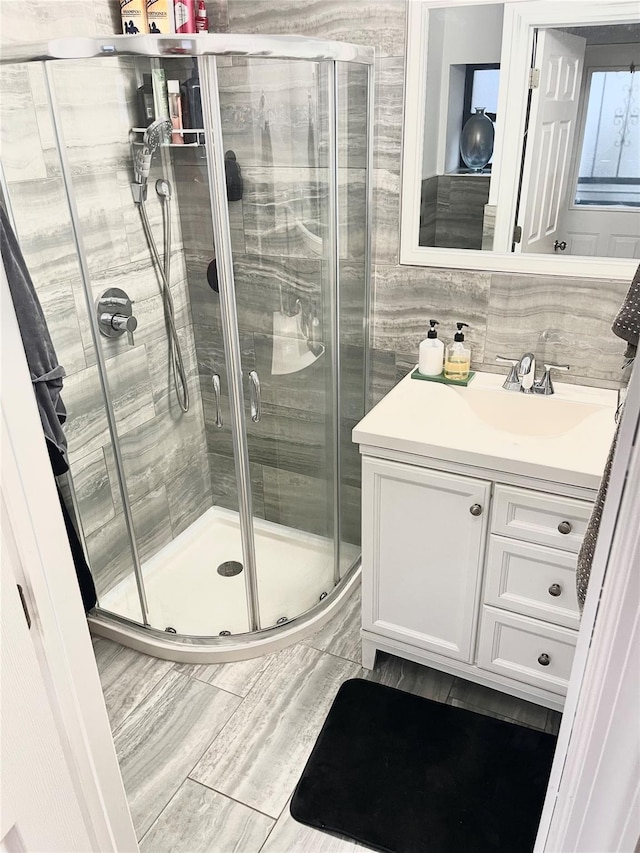 full bath with a shower stall and vanity