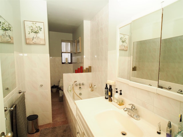 full bathroom with tile walls, a bath, vanity, and tile patterned floors