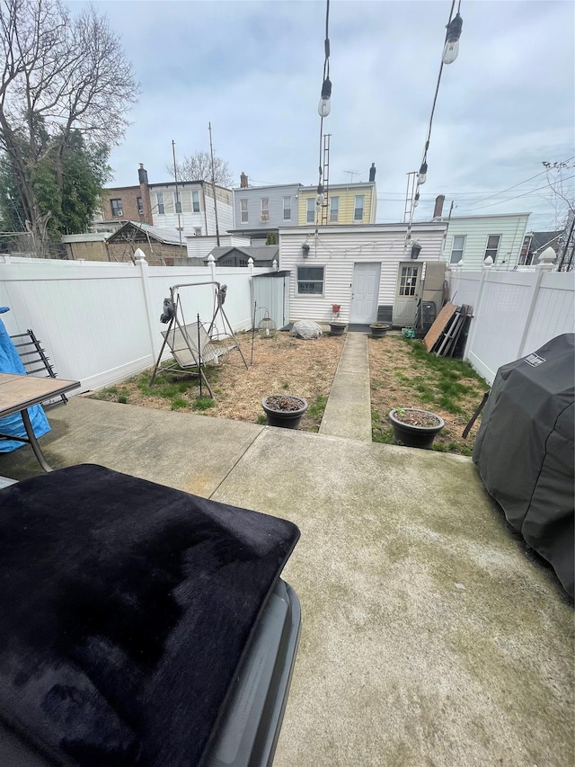fenced backyard with a patio area and a fire pit