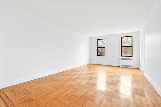 empty room featuring radiator heating unit and baseboards