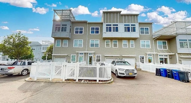 multi unit property featuring driveway and a garage