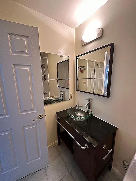 bathroom featuring vanity, tile patterned flooring, and baseboards