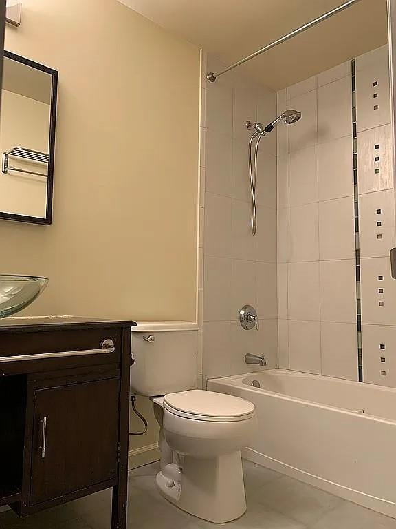 full bath with toilet,  shower combination, vanity, and baseboards