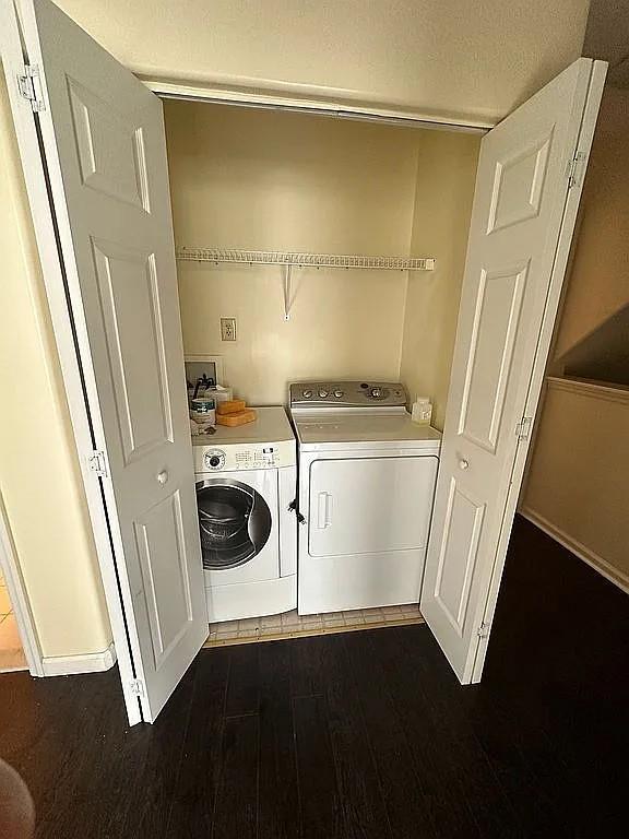 laundry room featuring washer and clothes dryer, dark wood-style floors, and baseboards