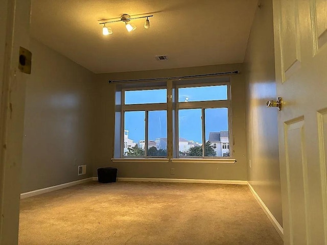 unfurnished room featuring carpet and baseboards