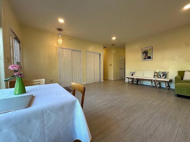 bedroom with two closets, recessed lighting, and baseboards