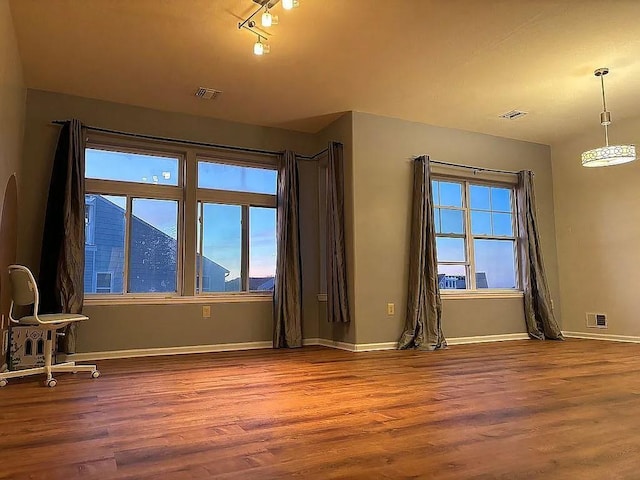 spare room featuring wood finished floors and baseboards
