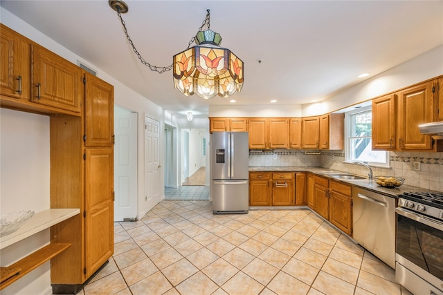 3 Benjamin Ct, Ardsley, NY 10502 - kitchen with stainless steel appliances, backsplash, brown cabinets, a sink, and light tile patterned floors