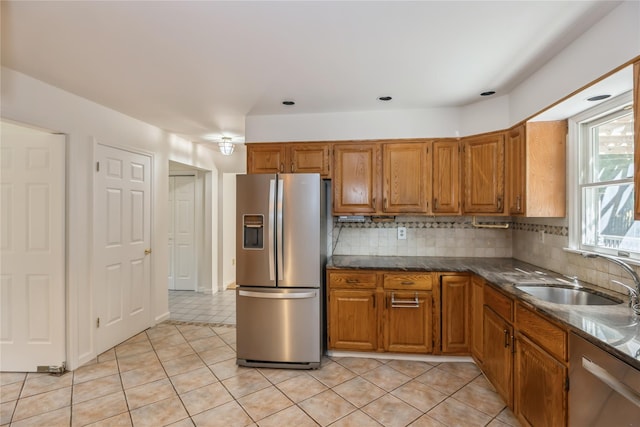 3 Benjamin Ct, Ardsley, NY 10502 - kitchen featuring appliances with stainless steel finishes, brown cabinetry, a sink, light tile patterned flooring, and backsplash