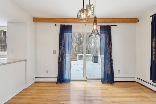 unfurnished dining area featuring beamed ceiling, a wealth of natural light, light wood-style flooring, and a baseboard radiator