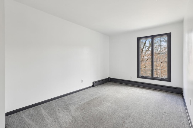 spare room with carpet floors, baseboards, and baseboard heating