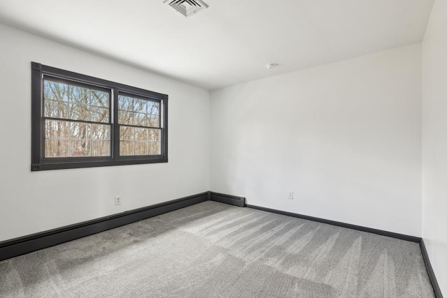 unfurnished room with baseboards, carpet flooring, a baseboard heating unit, and visible vents