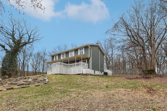 rear view of house with a lawn and cooling unit