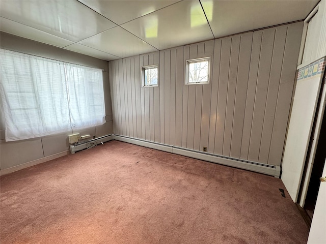 unfurnished room featuring a baseboard heating unit and carpet