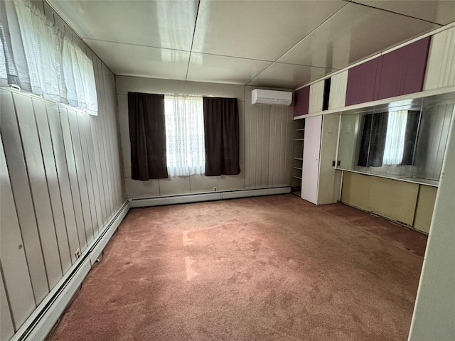 unfurnished bedroom with a baseboard heating unit, carpet, and a wall unit AC