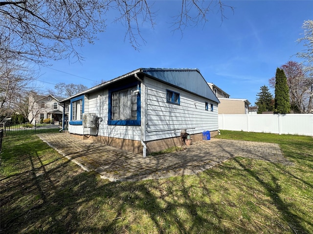 view of property exterior featuring a yard, fence, and a patio area