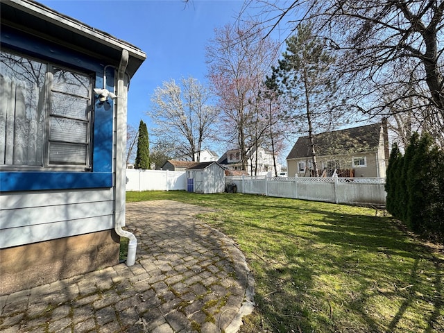 view of yard with an outdoor structure, a storage unit, a patio, and a fenced backyard