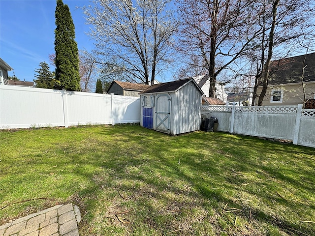 view of yard with a fenced backyard, an outbuilding, and a storage shed