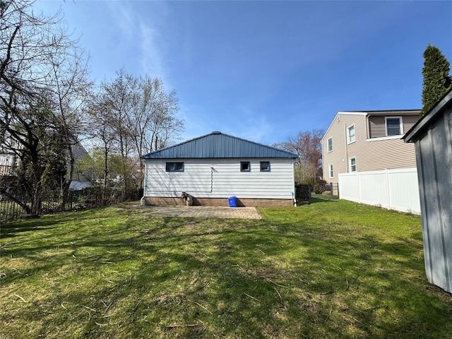 rear view of property featuring a yard and fence