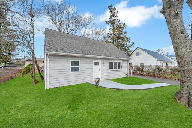 81 New Ave, Wyandanch, NY 11798 - rear view of house with a shingled roof and a yard