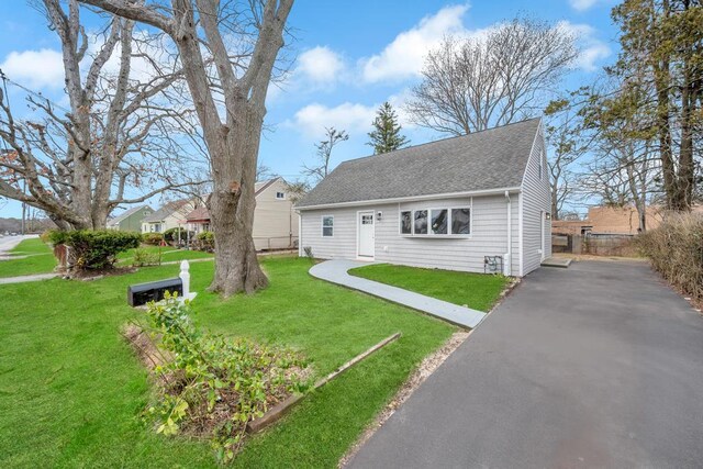 81 New Ave, Wyandanch, NY 11798 - view of front of home with a front lawn, aphalt driveway, fence, and a shingled roof