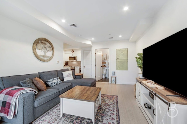 living area featuring light wood finished floors and recessed lighting