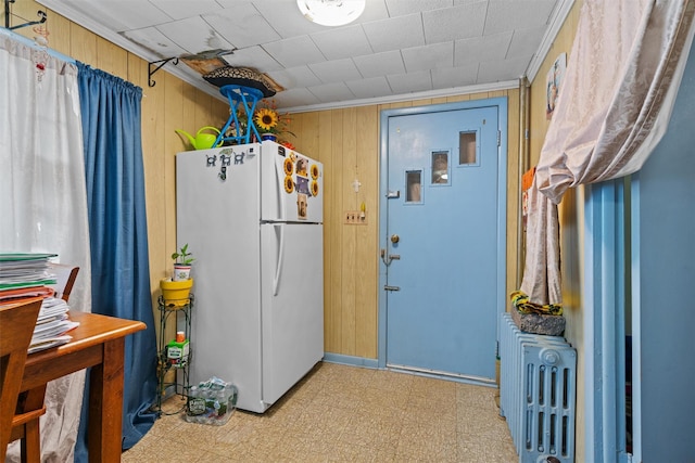 53 Dill Rd, Forestburgh, NY 12777 - kitchen featuring crown molding, wood walls, radiator heating unit, freestanding refrigerator, and light floors