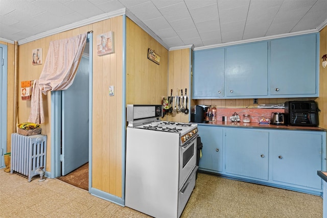 53 Dill Rd, Forestburgh, NY 12777 - kitchen featuring radiator, blue cabinets, white range with gas cooktop, and tile patterned floors