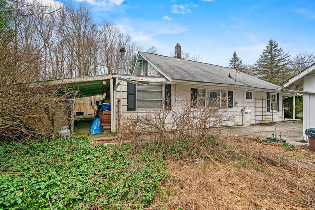 53 Dill Rd, Forestburgh, NY 12777 - view of front of house featuring an attached carport, a chimney, and a patio