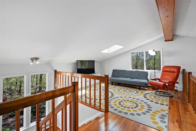 interior space featuring wood-type flooring, baseboard heating, a healthy amount of sunlight, and lofted ceiling with skylight