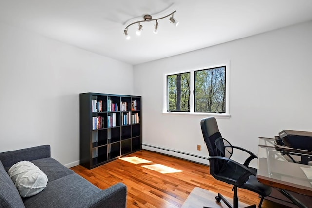 office area featuring wood finished floors and a baseboard radiator