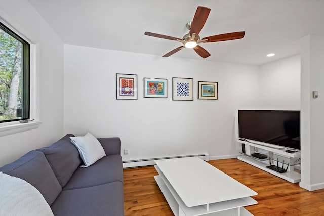 living room with a ceiling fan, recessed lighting, baseboard heating, and wood finished floors