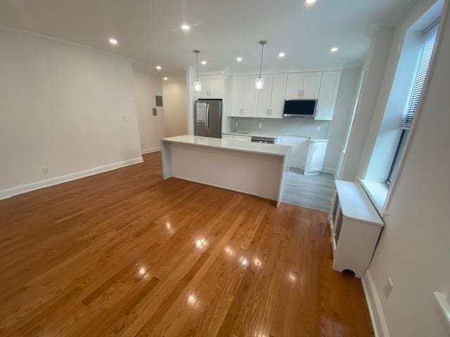kitchen featuring a center island, recessed lighting, white cabinetry, and stainless steel appliances