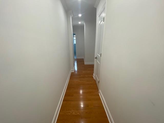corridor with baseboards, recessed lighting, and wood finished floors