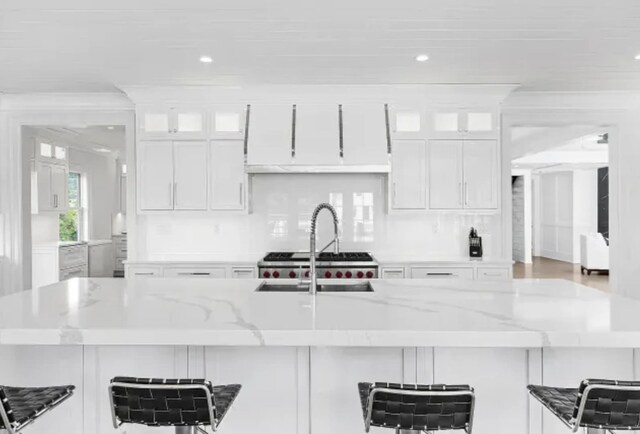 3505 Bay Front Dr, Baldwin Harbor, NY 11510 - kitchen featuring white cabinets, recessed lighting, light stone countertops, and a sink