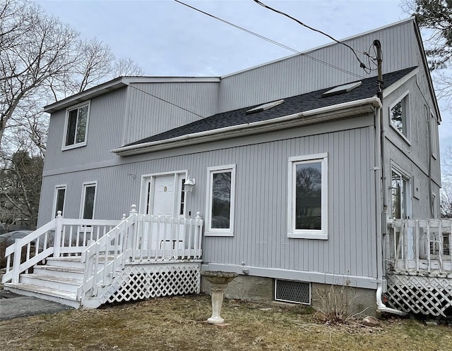 back of property with a shingled roof