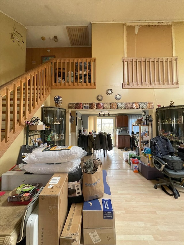living area with wood finished floors and a towering ceiling