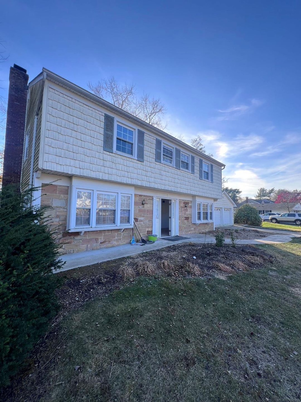 6 Blackwell Ln, Stony Brook, NY 11790 - view of front of home featuring stone siding, a front yard, and a chimney