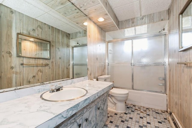 full bath featuring toilet, wood walls, a baseboard heating unit, and enclosed tub / shower combo