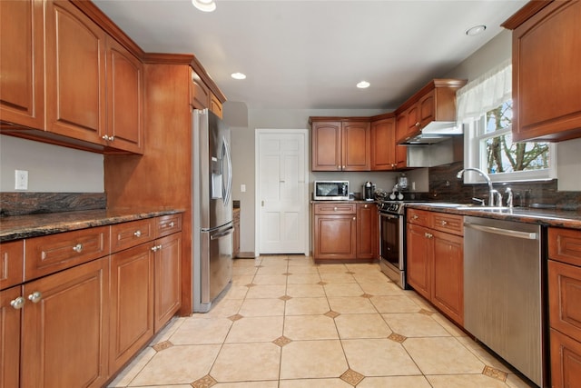 kitchen featuring a sink, brown cabinetry, appliances with stainless steel finishes, and recessed lighting
