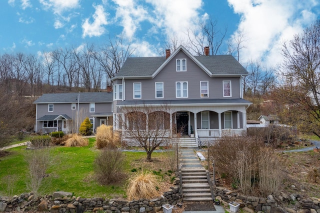 view of front of property with roof with shingles, stairs, a porch, and a chimney