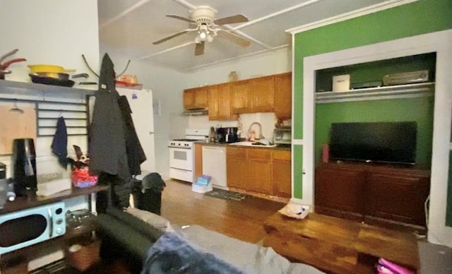 kitchen with ceiling fan, white appliances, brown cabinetry, under cabinet range hood, and a sink