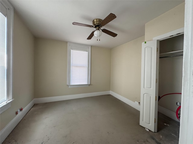unfurnished bedroom with concrete flooring, baseboards, and ceiling fan