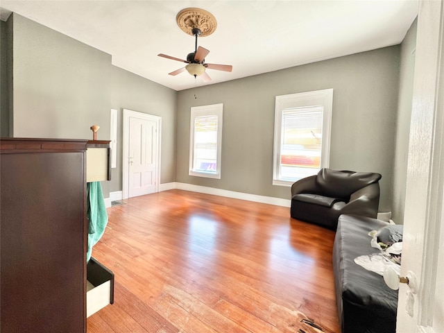 sitting room with baseboards, a ceiling fan, and wood finished floors
